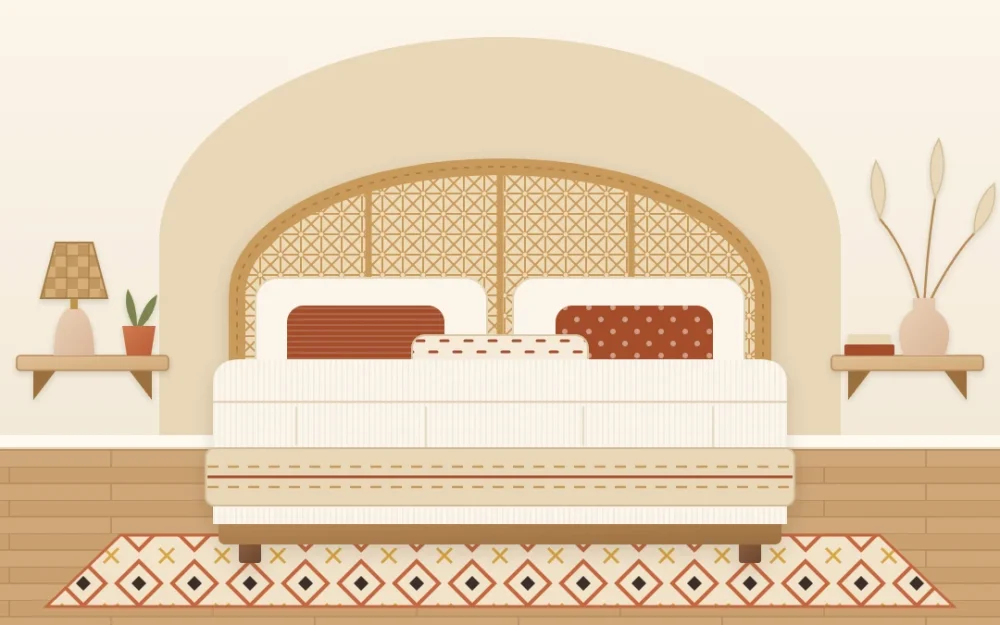 A bed with a wide arched rattan cane headboard, cream bedding and rust pillows in front of a painted sand-colored arch