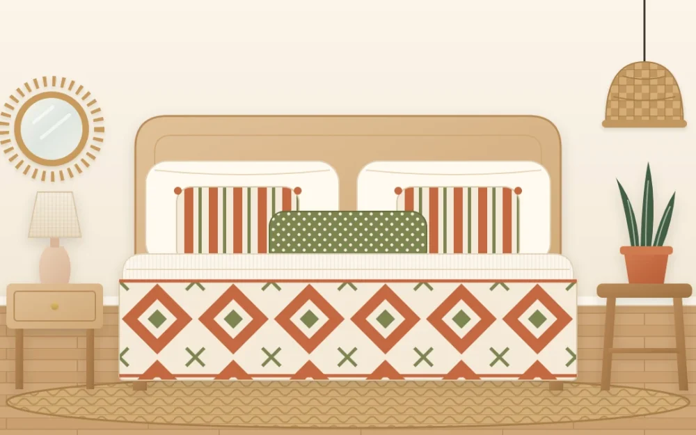 Bed seen from the foot end with a large diamond-pattern quilt, medium striped pillows and a small dotted lumbar pillow in terracotta, cream and olive